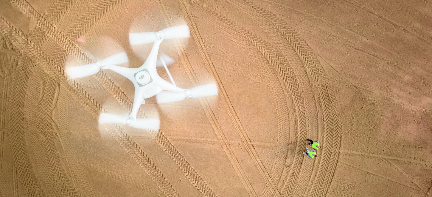 Drohne schwebt auf Baustelle über zwei Personen